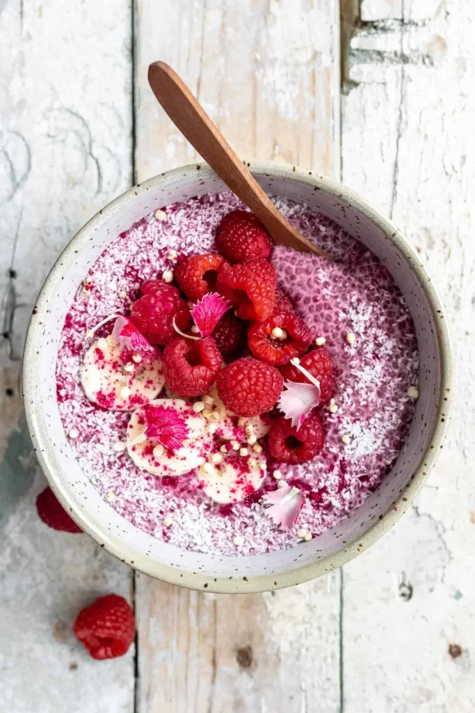 Creamy raspberry chia pudding topped with fresh raspberries and mint leaves.